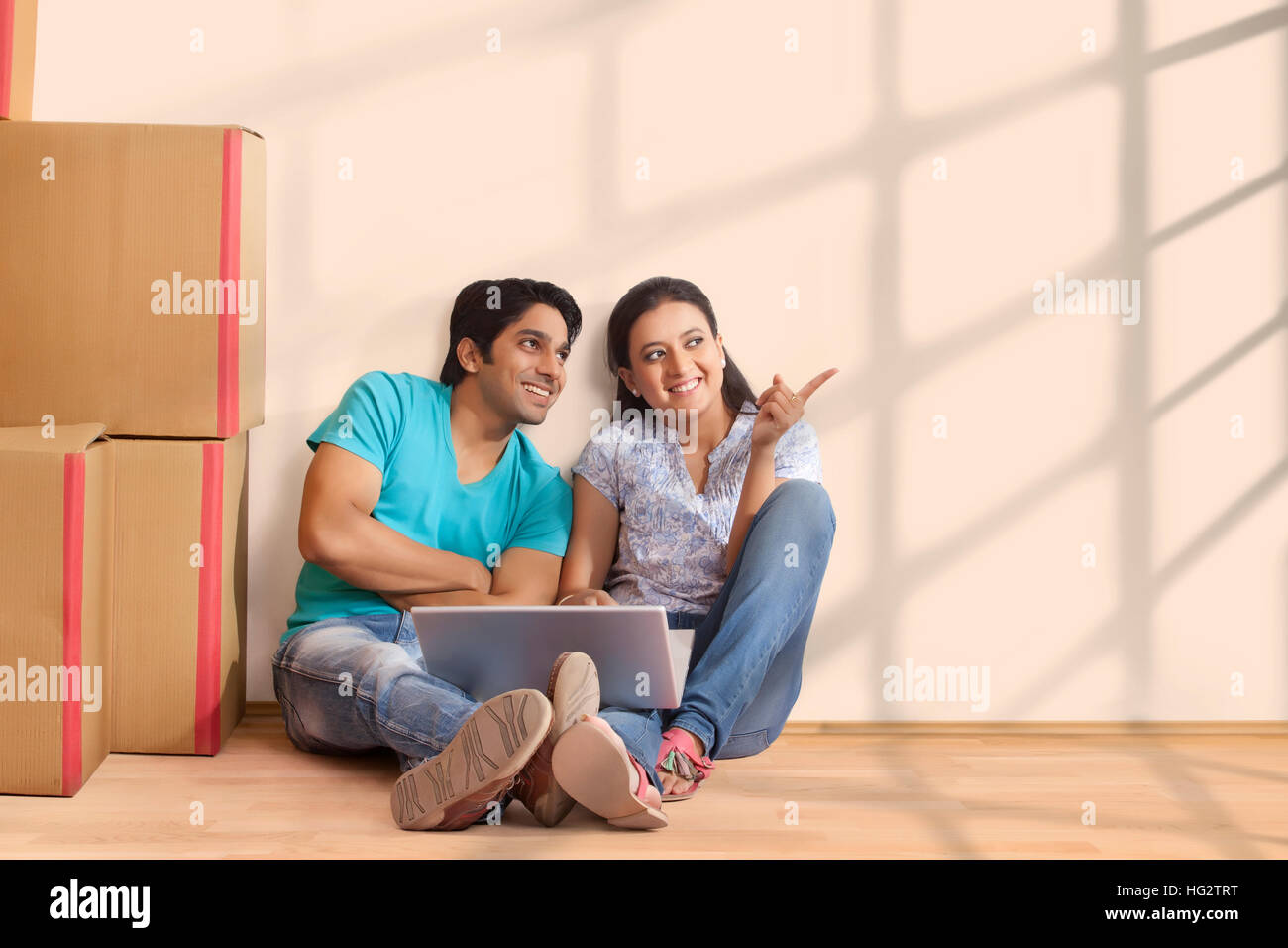 Happy mature couple pointing with finger to show something at new home Stock Photo
