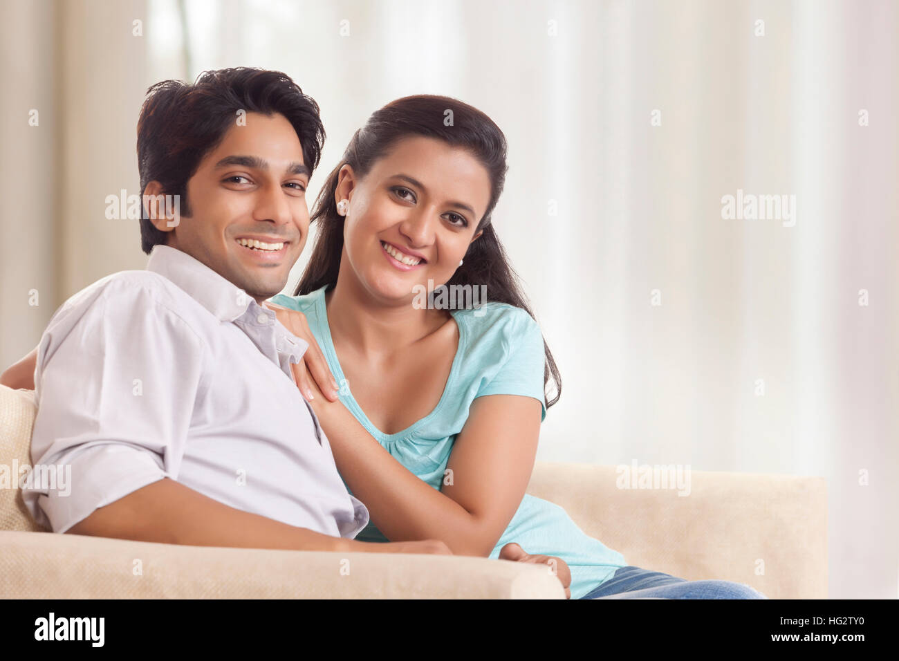 Portrait of smiling young couple at home Stock Photo - Alamy