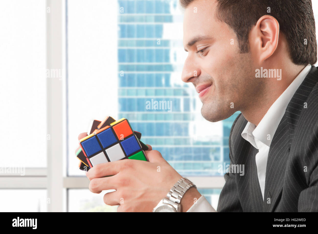 Businessman holding rubik cube in his hands Stock Photo