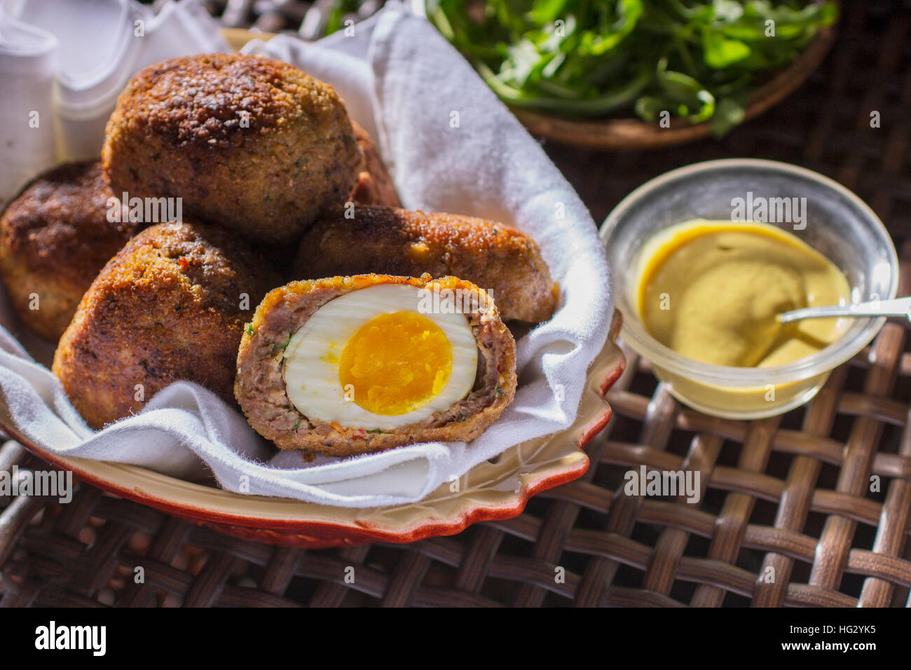 Scotch Eggs in Oval Dish with Spicy Mustard Sauce and Arugula Stock