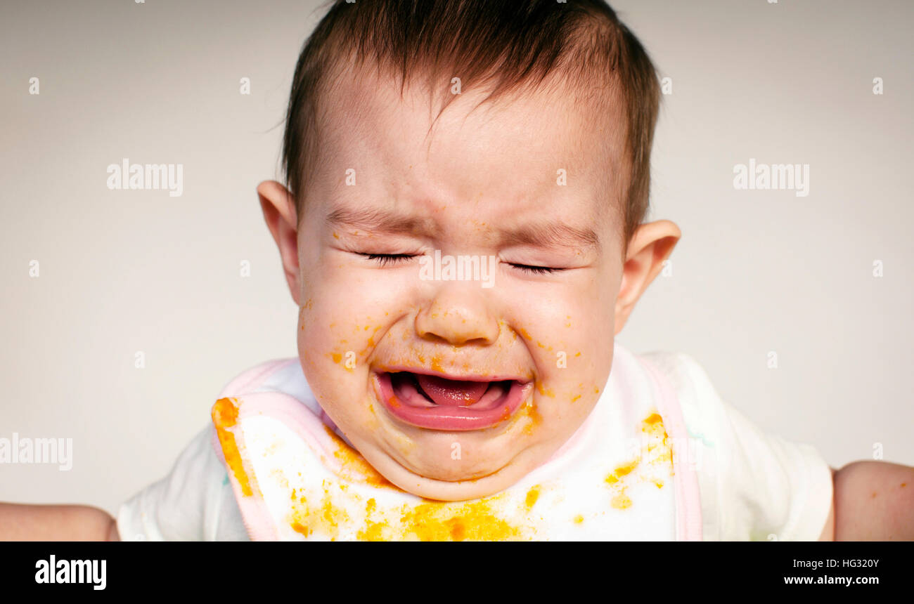Baby crying during mealtime Stock Photo