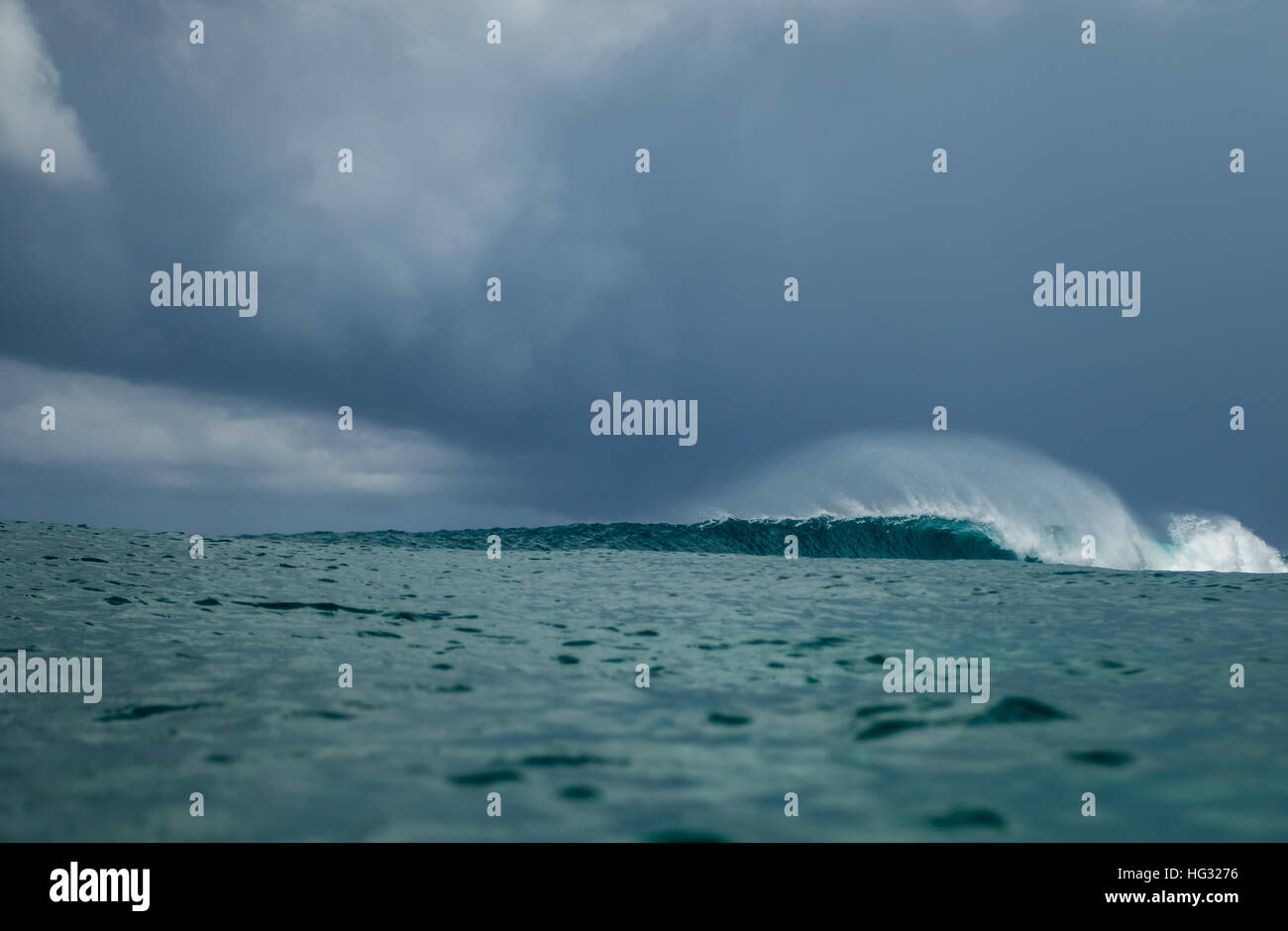 Large wave moody blue sky white spray stormy calm perfect surf Stock Photo