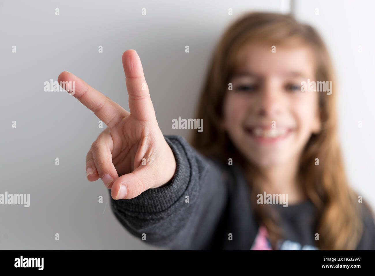 Girl with index fingers and heart, or up and her face out of focus ...