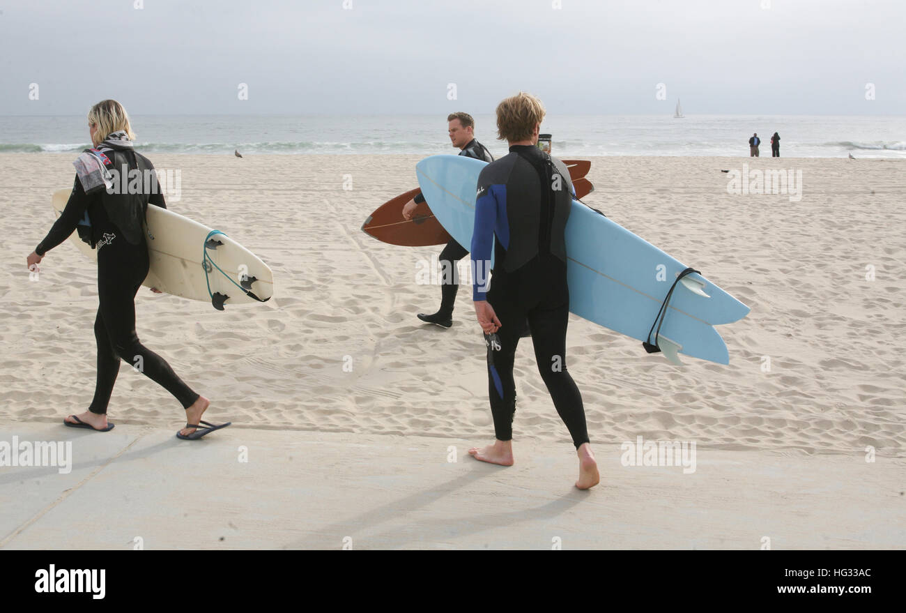 Surfer,surfers,wetsuits,looking,at,waves, with surfboard at. Venice