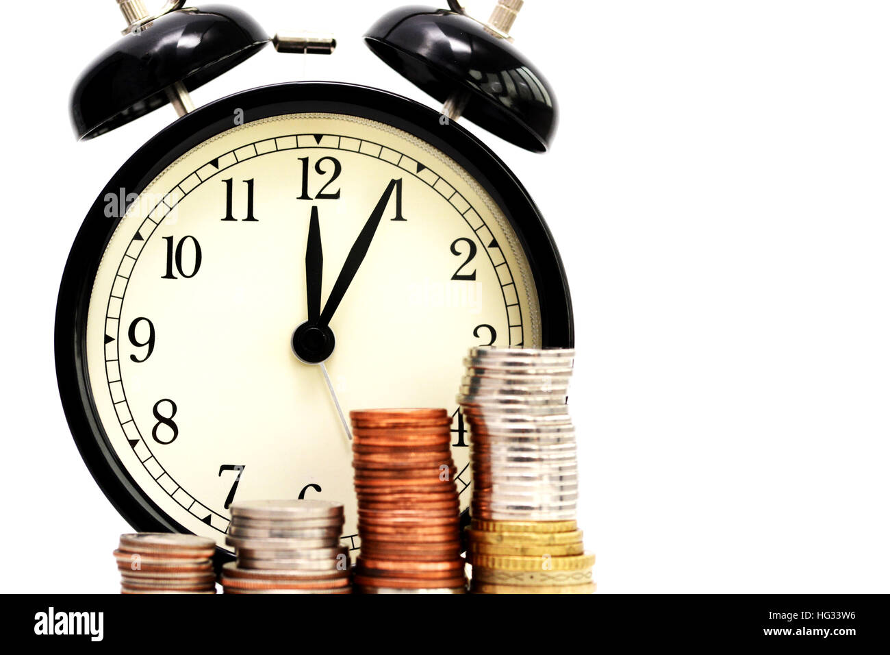 Old alarm clock and stacks of coins, time efficiency concept Stock Photo