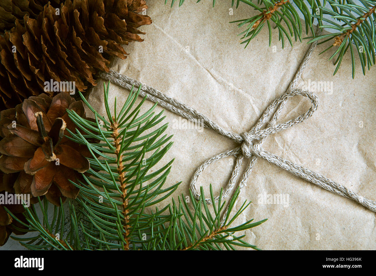 Gift wrapped craft paper with pine cones and fir branches, top view ...