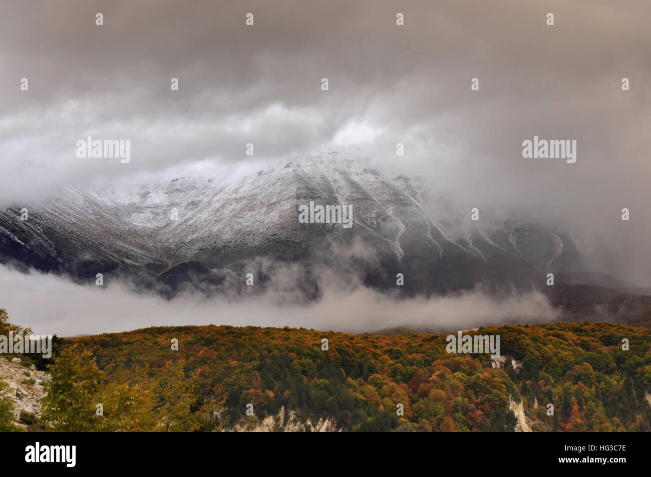 The first snow has fallen on the mountain even when the leaves of trees ...