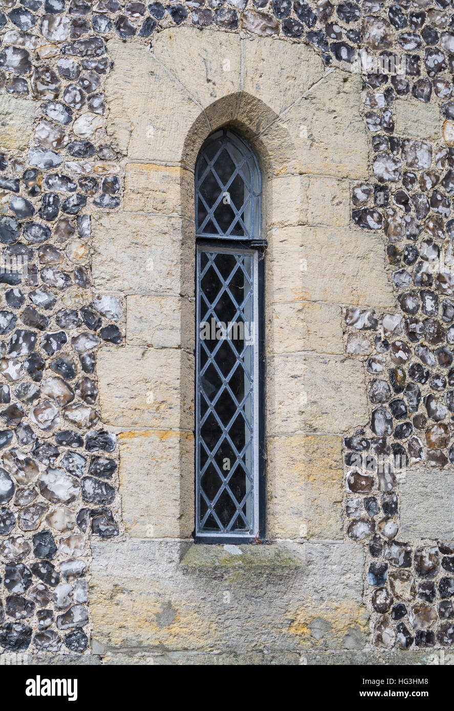 Arrow Loop window with modern glazing in an old Medieval castle in the UK. Arrow slit. Stock Photo