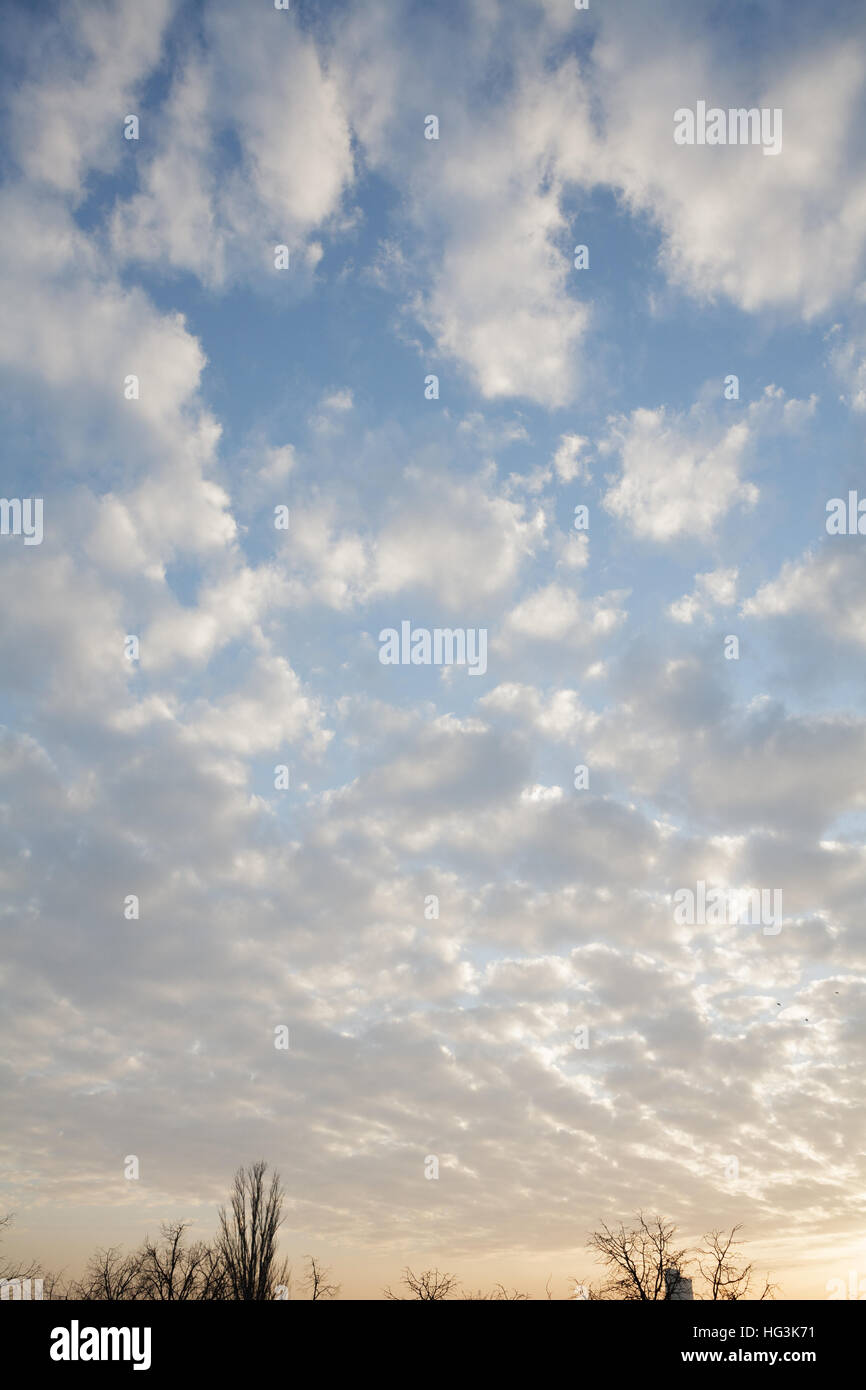 Blue sky and fluffy clouds at sunset Stock Photo - Alamy