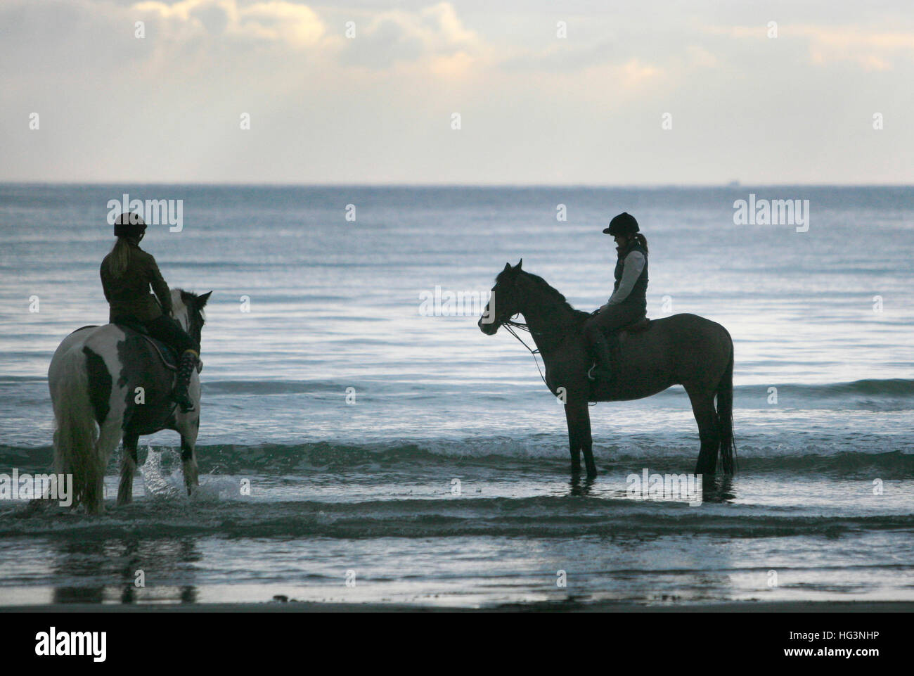 Women ride their horses in the sea at Pendower Beach, in Cornwall, Britain December 31, 2016. © John Voos Stock Photo
