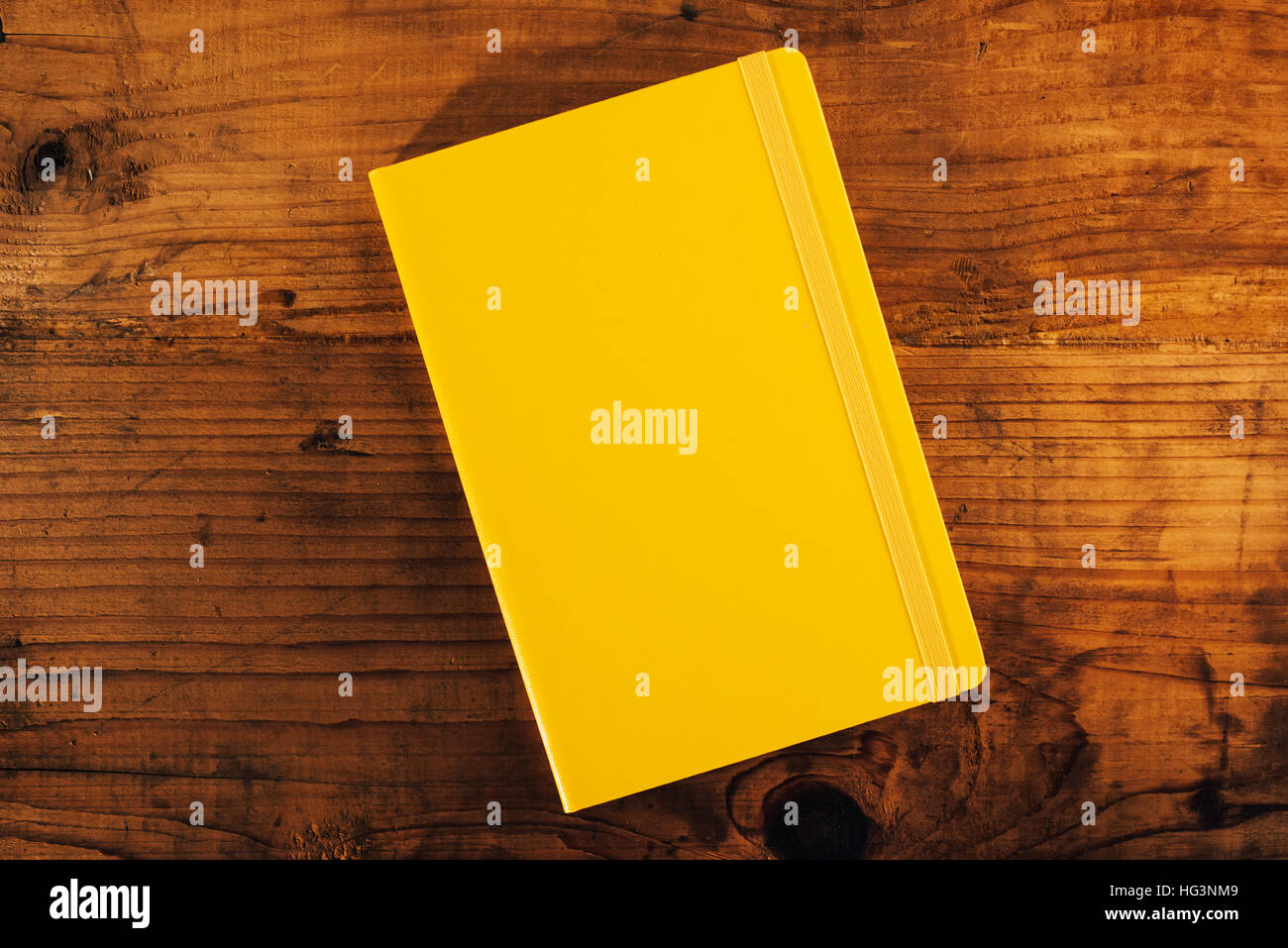 Yellow notebook on rustic wooden office desk, top view, copy space Stock Photo