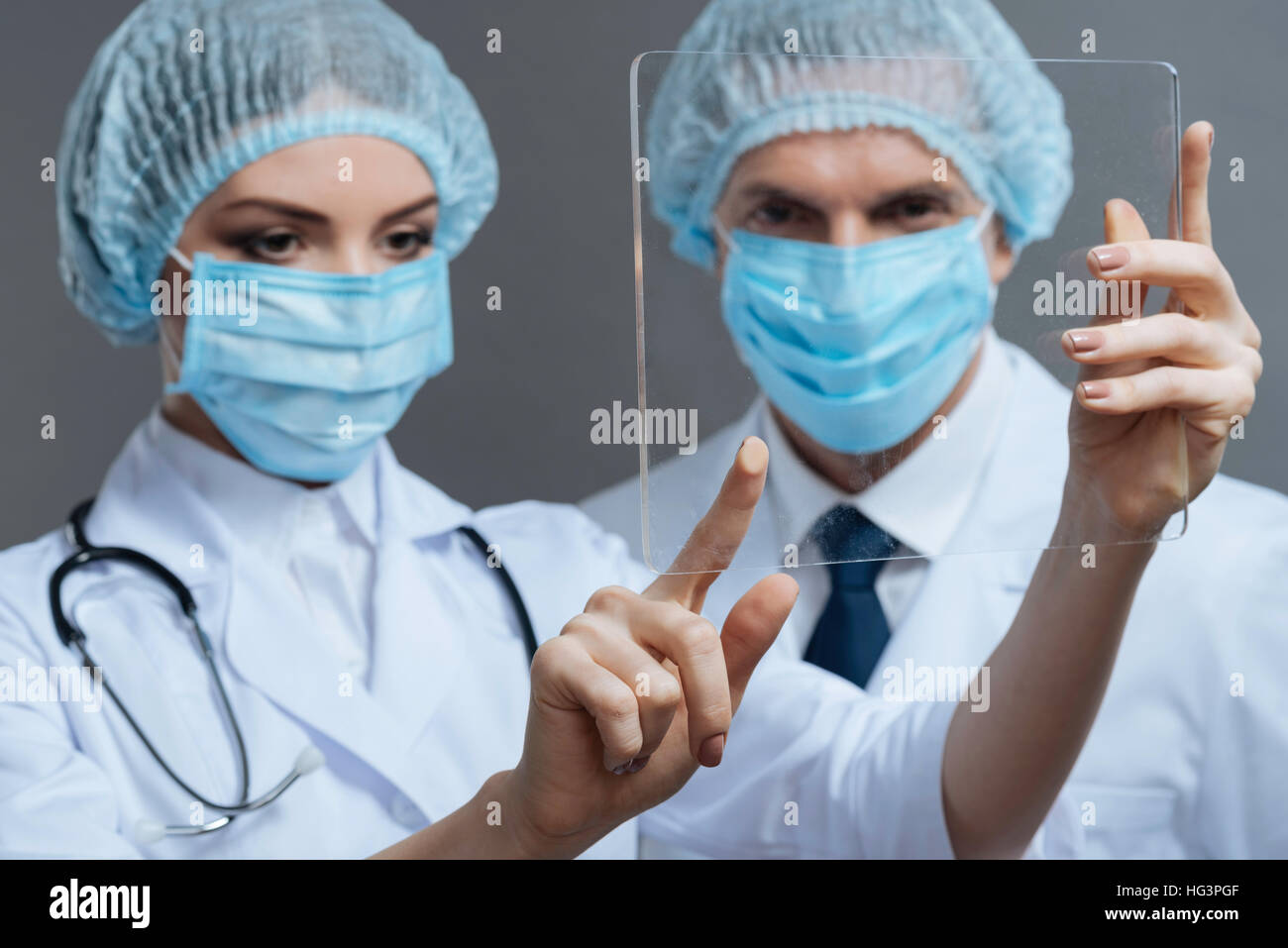 Touching Glass Injection Concentrated colleagues touching medical glass Stock Photo - Alamy