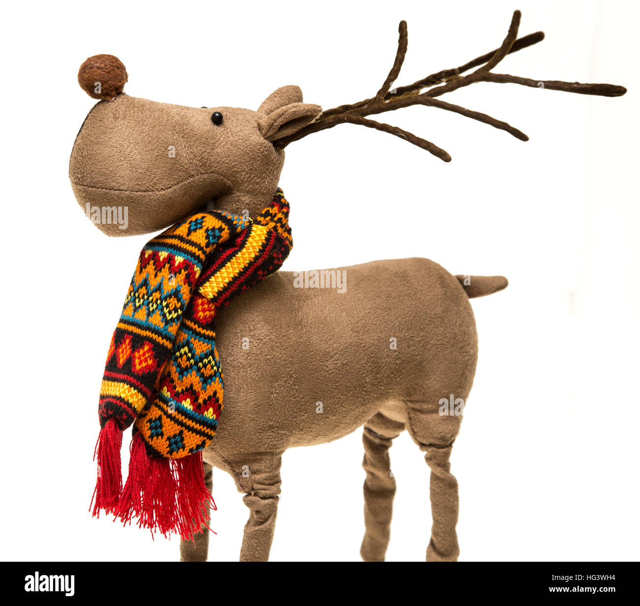 A Christmas decoration of Rudolph the red-nosed reindeer, wearing a colourful scarf on a white background. Stock Photo