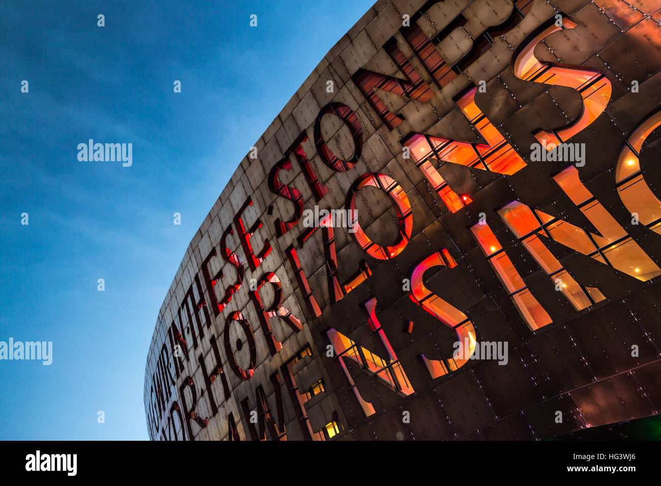 Cardiff's Wales Millennium Centre arts complex lit in early evening, Cardiff Bay, Glamorgan, Wales, UK Stock Photo