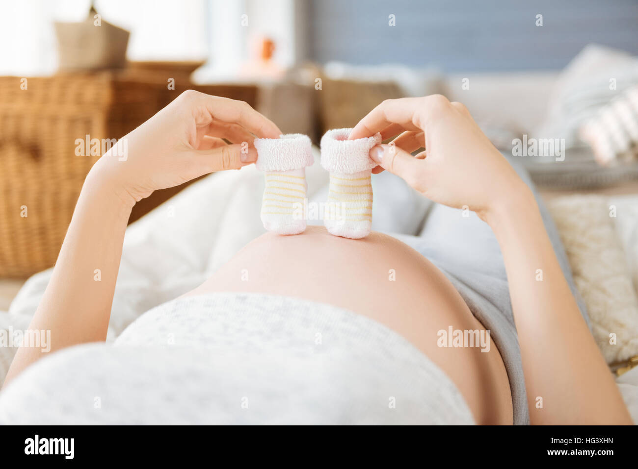 Close up of a pregnant woman demonstrating baby socks Stock Photo