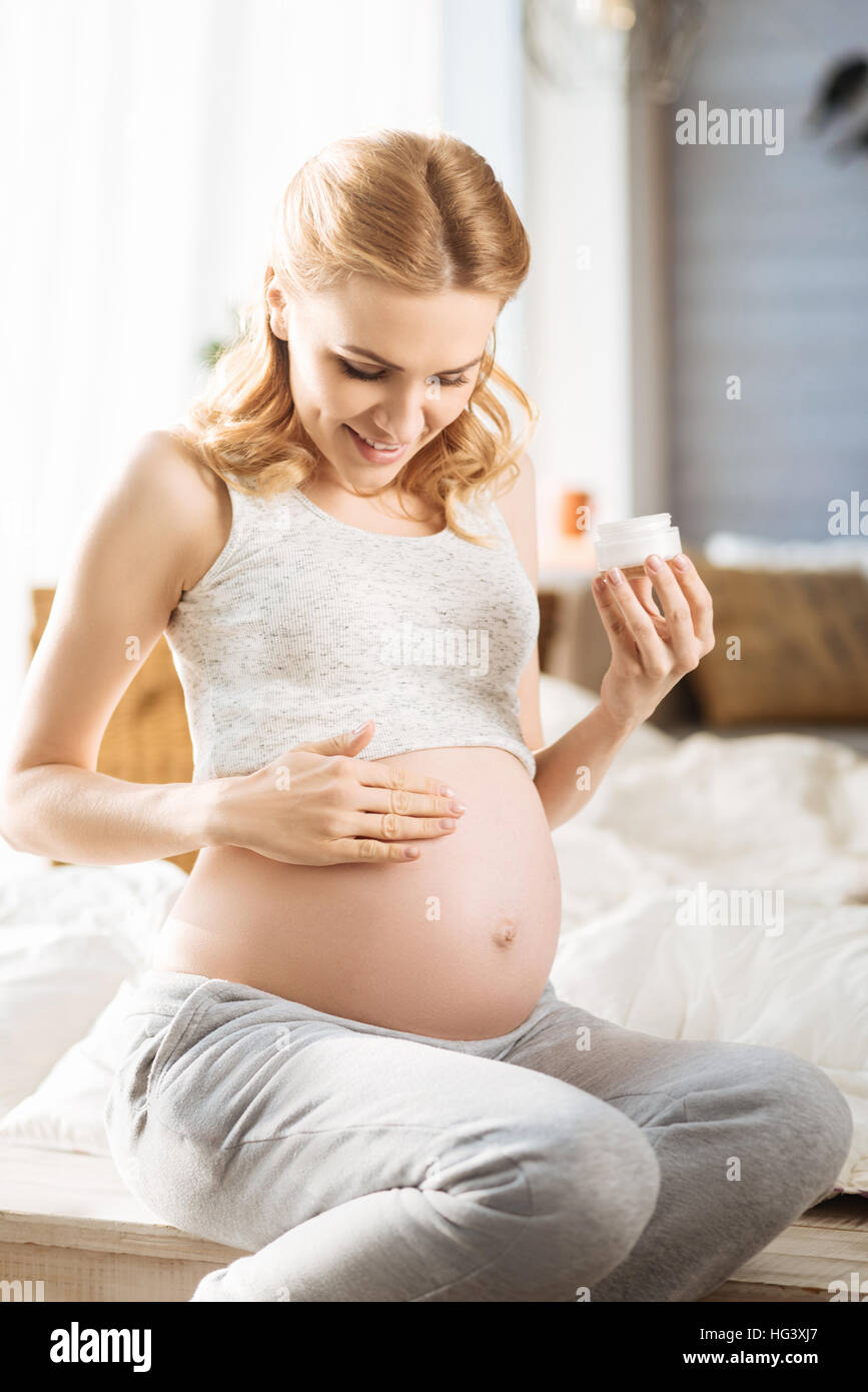 Pregnant woman using a care cream Stock Photo