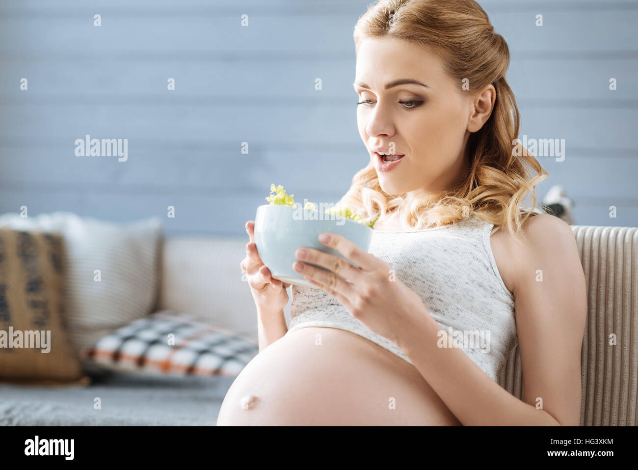 Pregnant woman holding a plate with salad Stock Photo