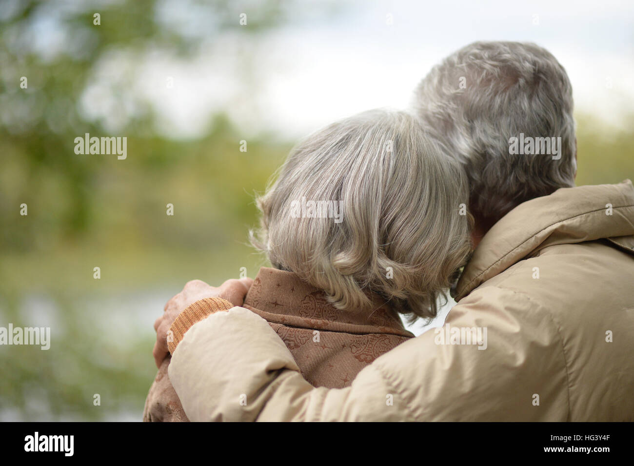 Elderly couple with his back embracing in autumn park Stock Photo - Alamy