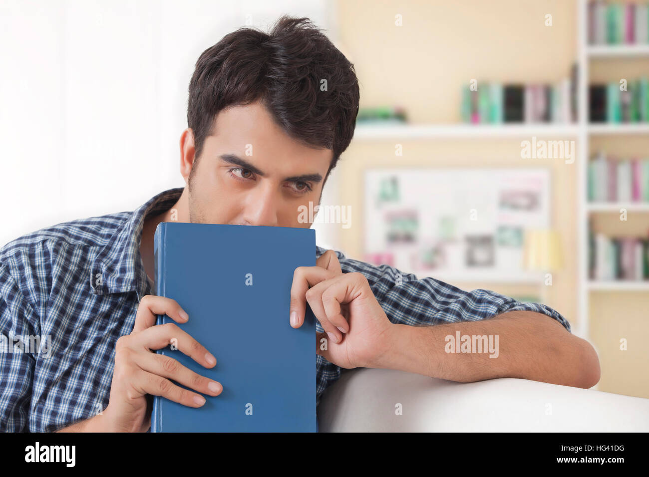 Young man holding book and looking away Stock Photo
