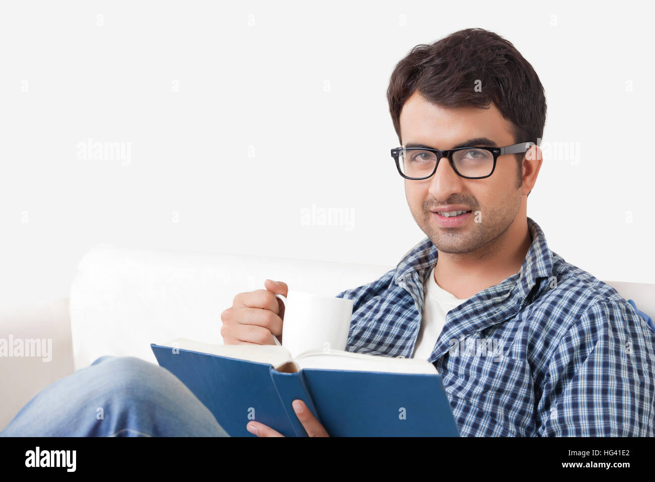 Young man reading book and drinking coffee Stock Photo