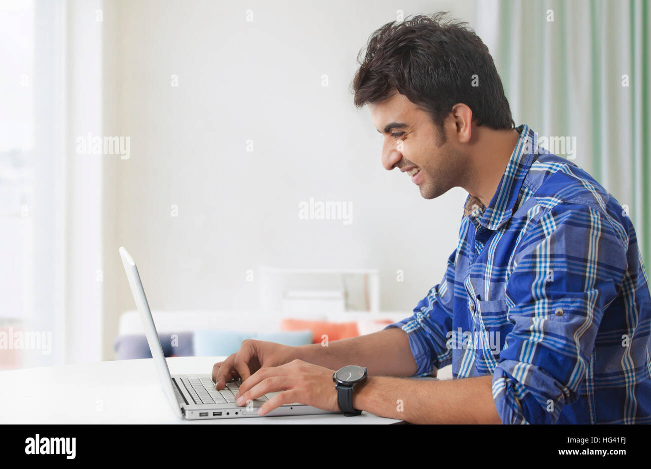 Smiling man using laptop computer Stock Photo
