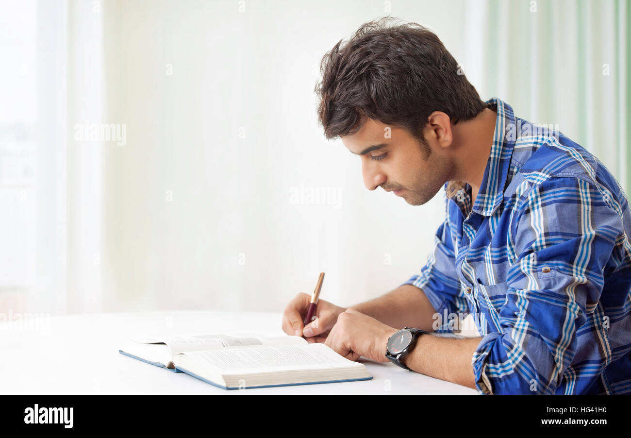 Young man studying and making notes Stock Photo