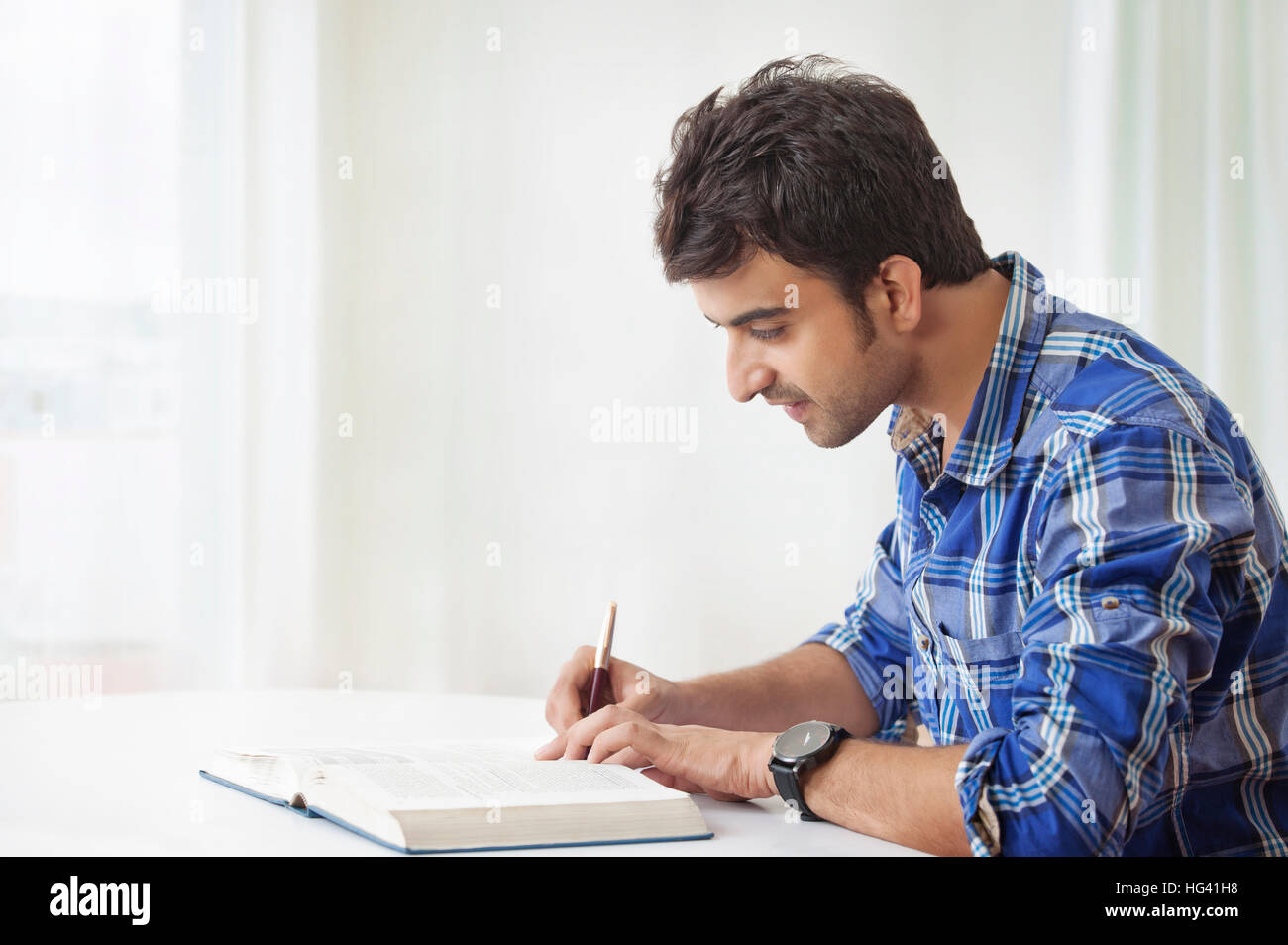 Young man studying and making notes Stock Photo