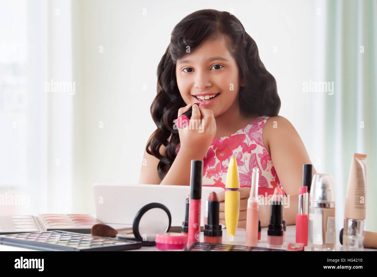 Cute girl putting on lipstick at home Stock Photo Alamy