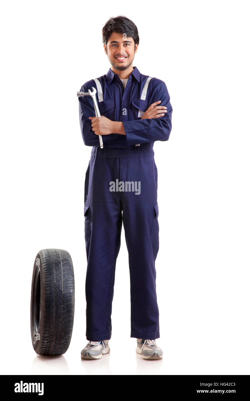 Portrait of car mechanic with spare tyre Stock Photo