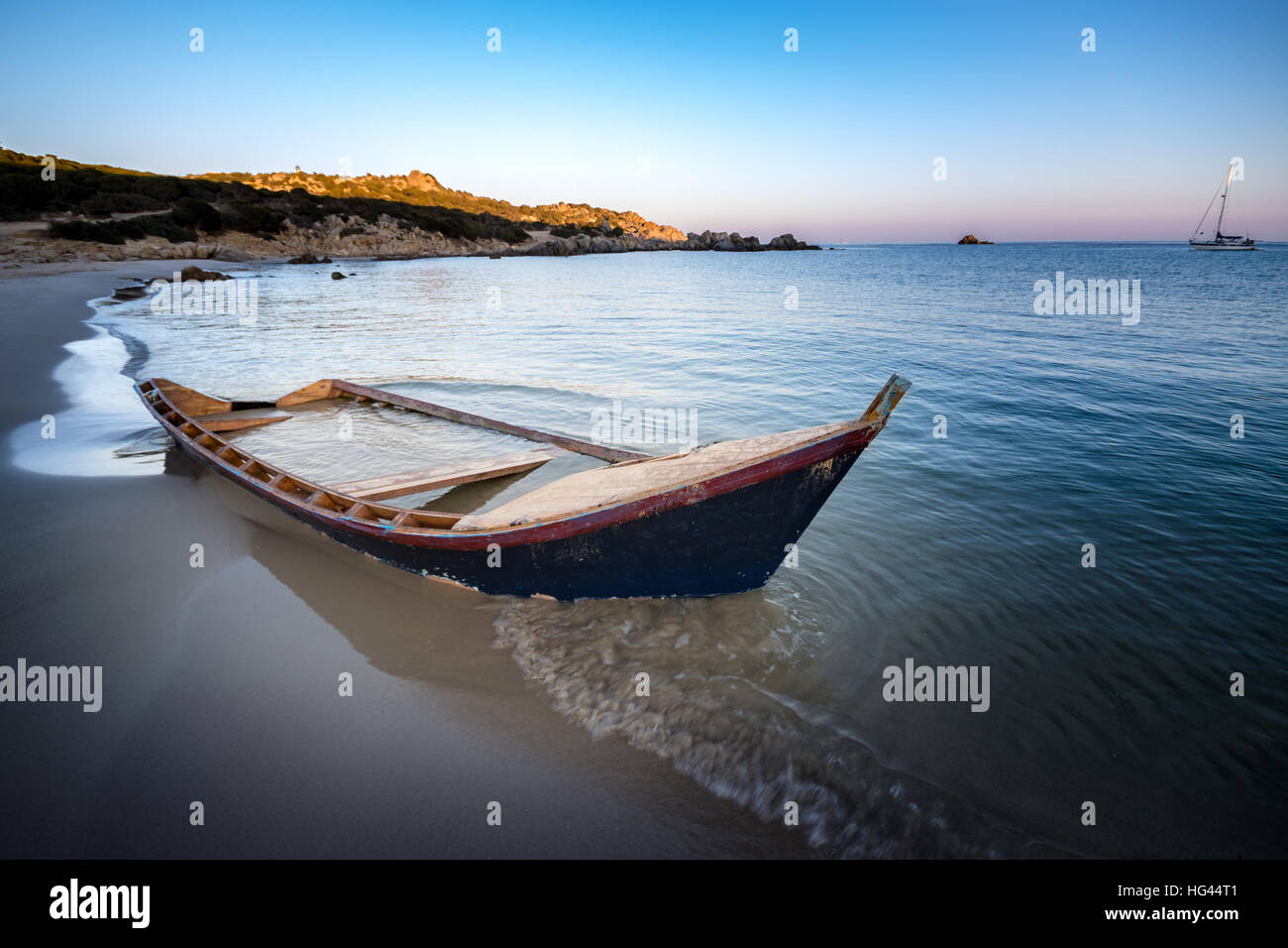 Old wooden boat wrecked on a sandy beach. Stock Photo