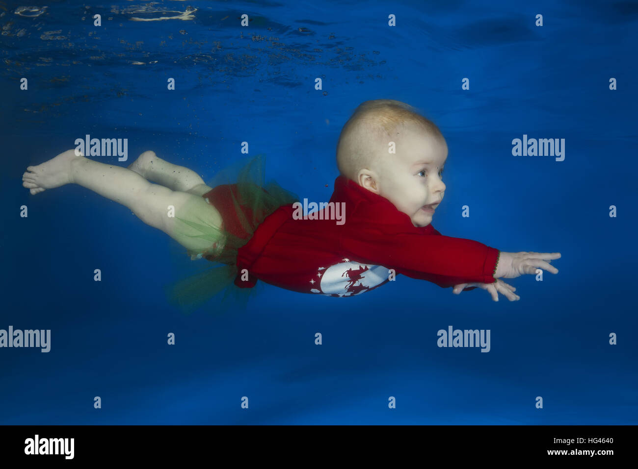 little child learns to swim underwater in the pool Stock Photo