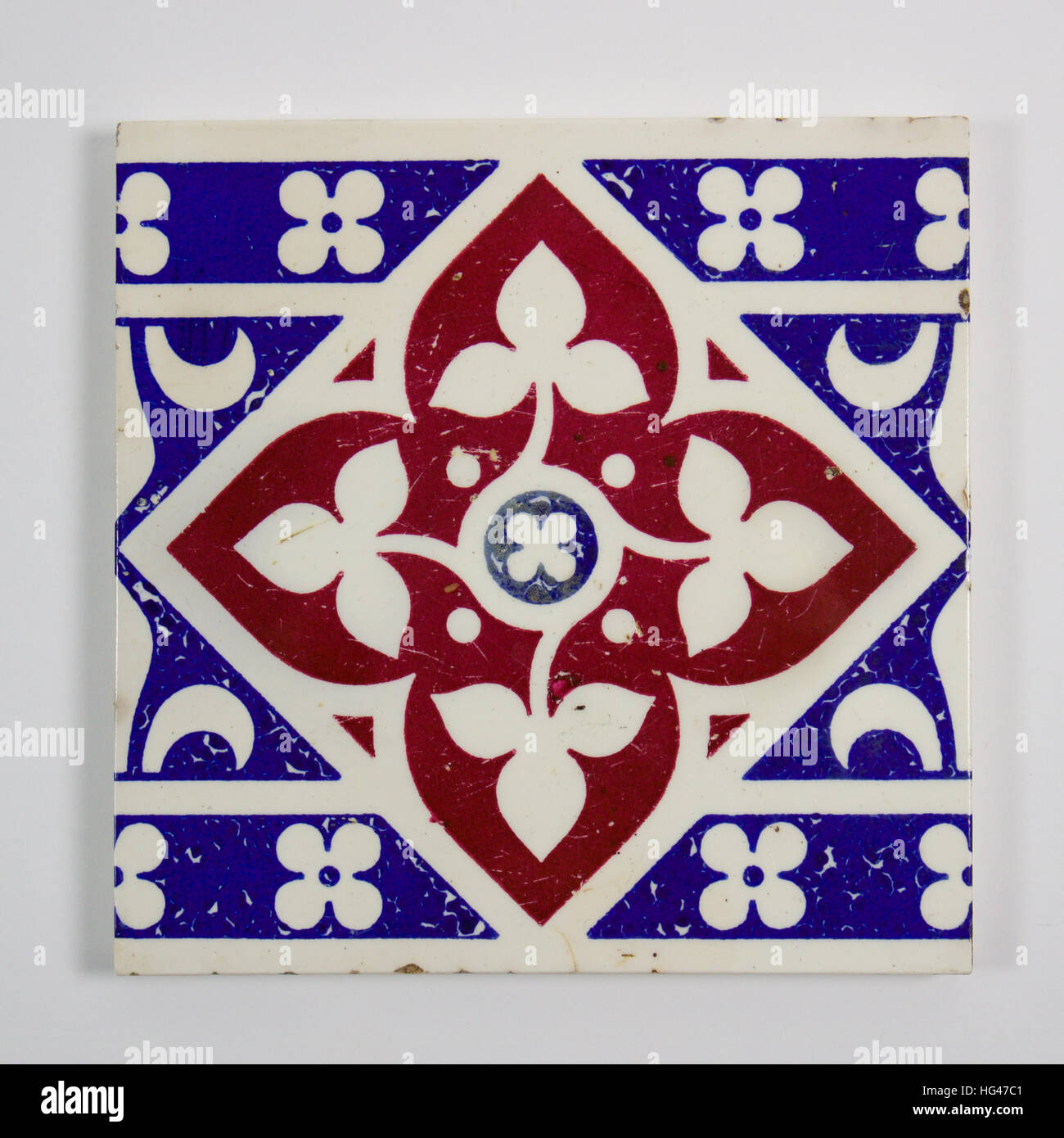 Antique Minton Gothic Revival tile designed by A.W.N. Pugin circa 1850. Printed in red and blue with fles de lys and quatrefoils. The tile measures ap Stock Photo