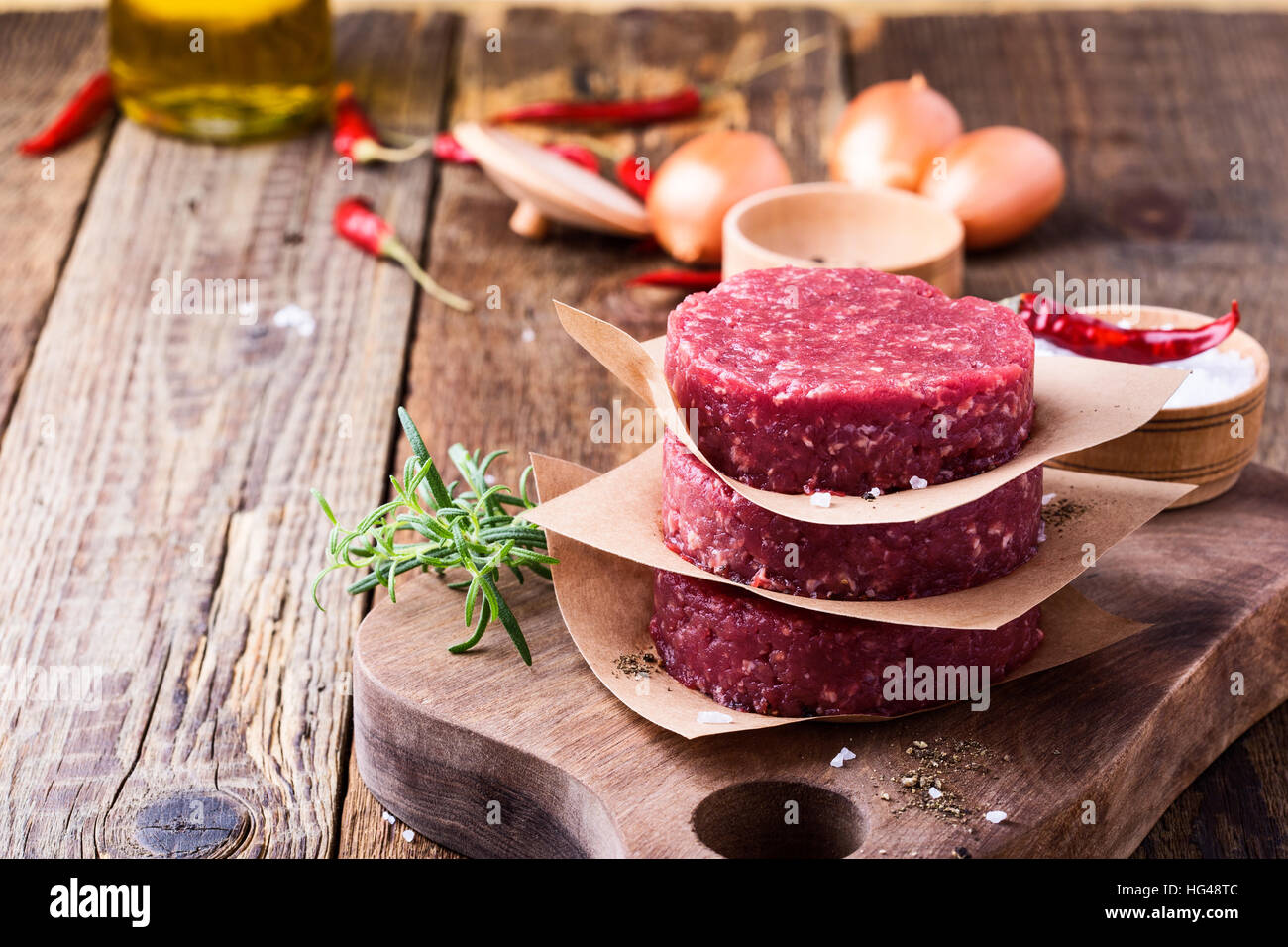 Organic raw ground beef, round patties for making homemade burger on wooden cutting board Stock