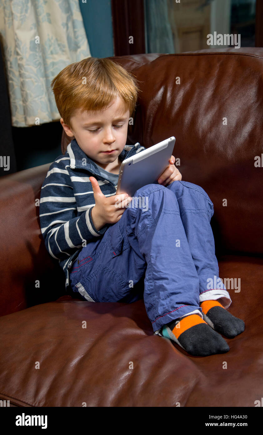 Child using technology. 5 year old boy with a tablet computer or iPad