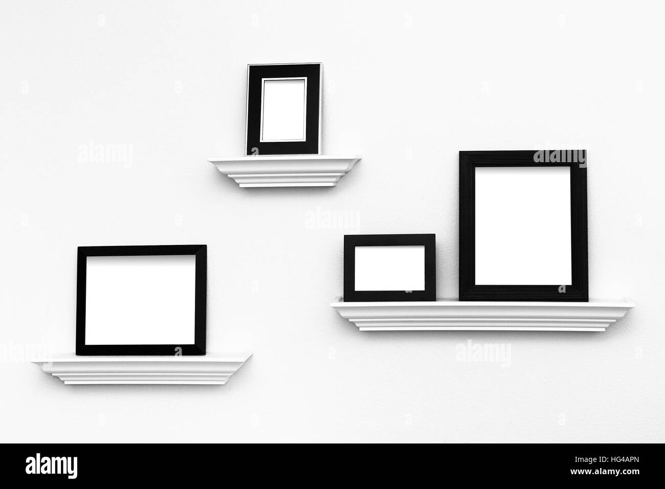 Multiple black and white picture frames on picture ledges attached to a
