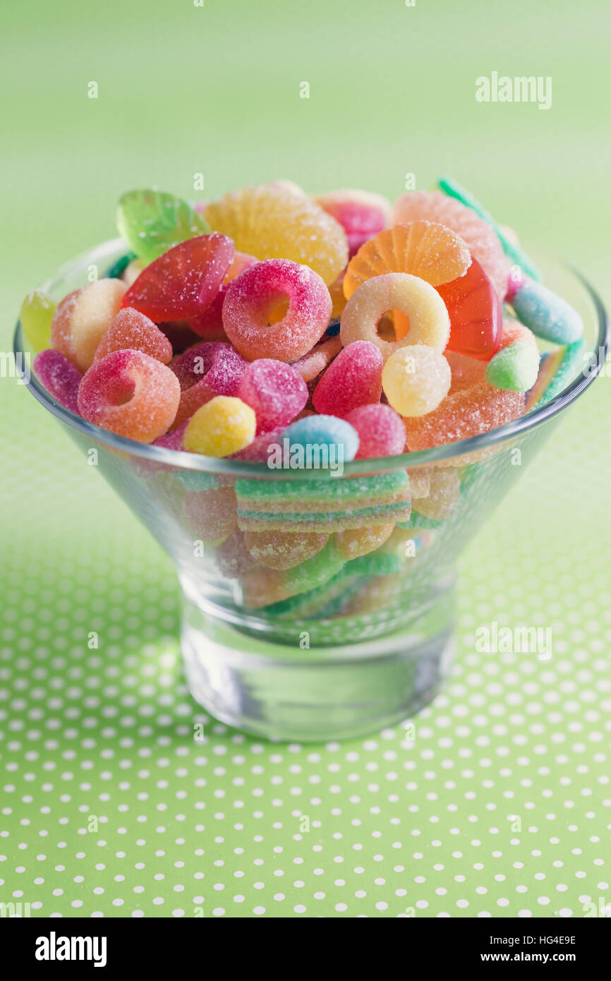 Glass bowl filled with brightly colored sweets (fruity jelly sweets). Stock Photo