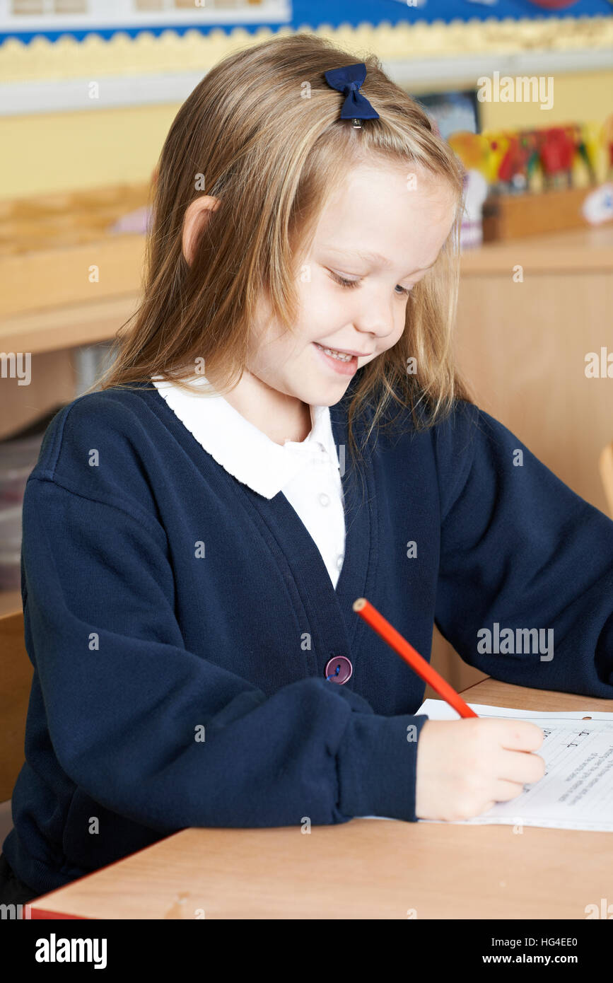 Female Elementary School Pupil Working At Desk Stock Photo - Alamy