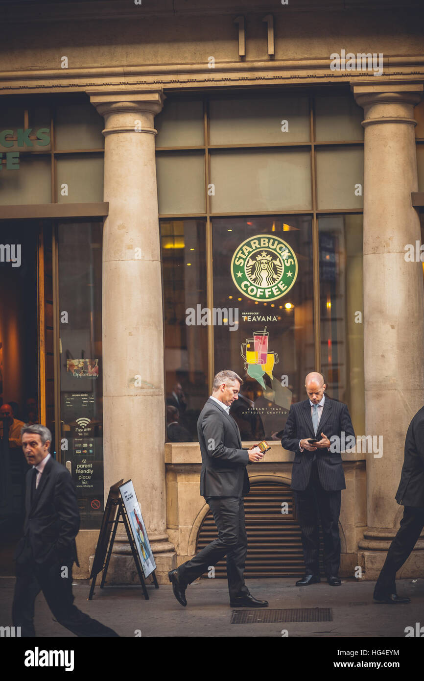 London Starbucks coffee, business men in front of the coffee bar with smartphone in hand Stock Photo