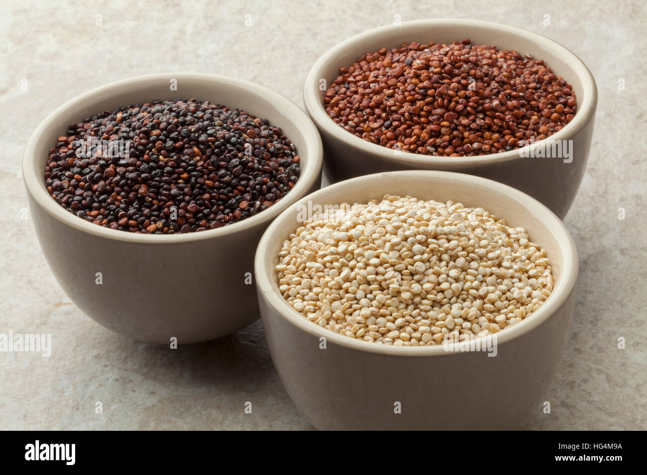 Bowls with raw red, white and black quinoa Stock Photo