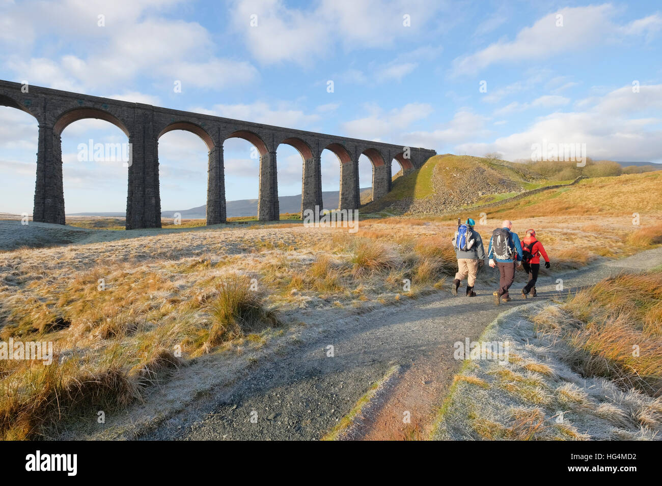 Walkers pass the Ribblehead viaduct on their way to Whernside, North Yorkshire National Park, England, UK Stock Photo
