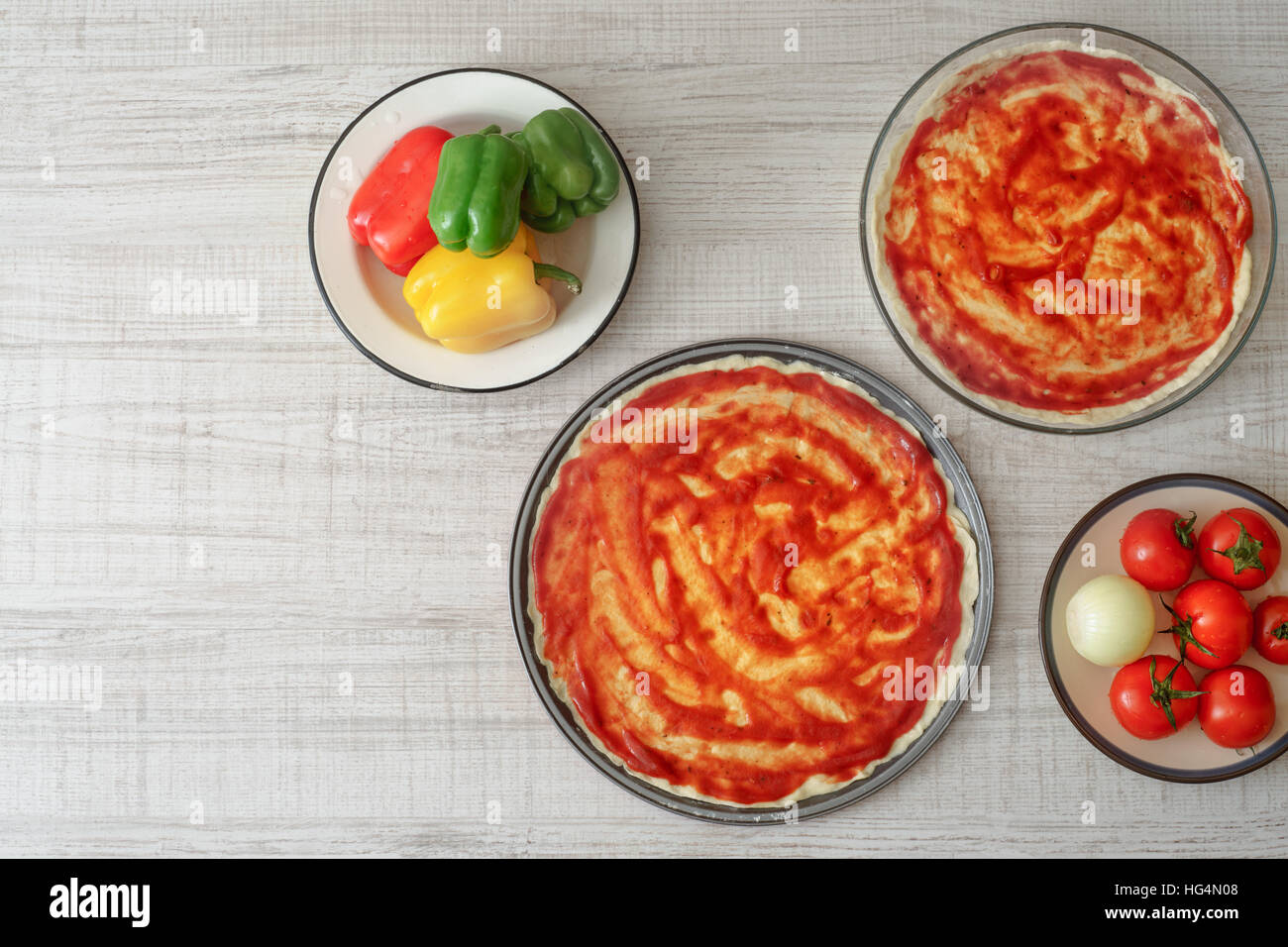 Ready dough for pizzas in forms for baking and ingredient horizontal Stock Photo