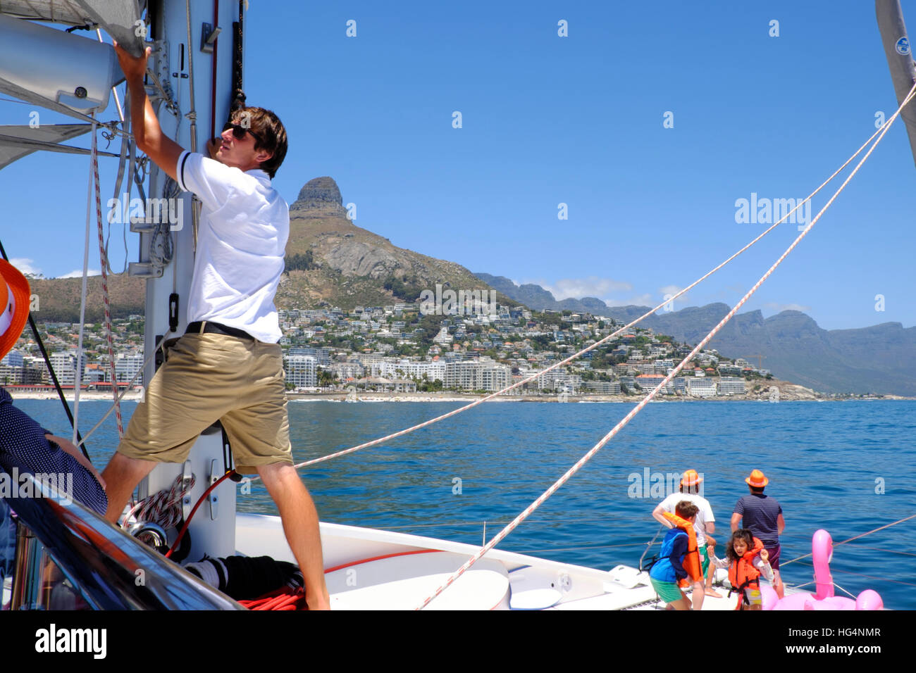 A crewman works on the rigging of luxury yacht as it approaches Lions