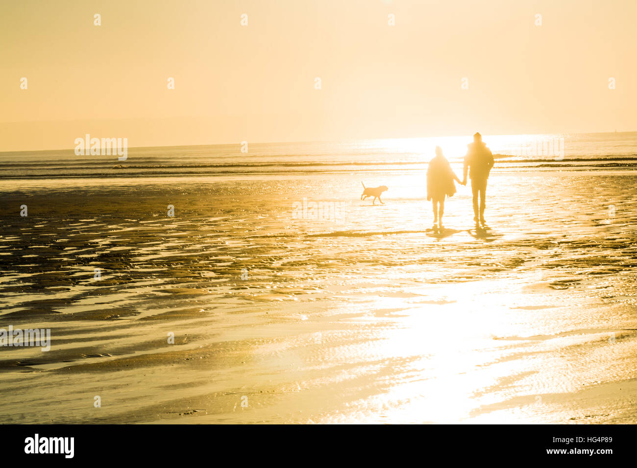 A couple walking on the beach in the evening Stock Photo