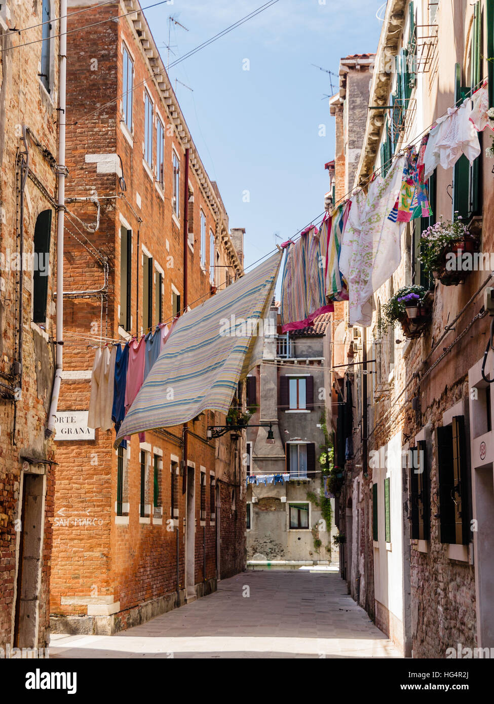 Typical street scene in Venice, Italy, with washing hanging between the town houses. Stock Photo