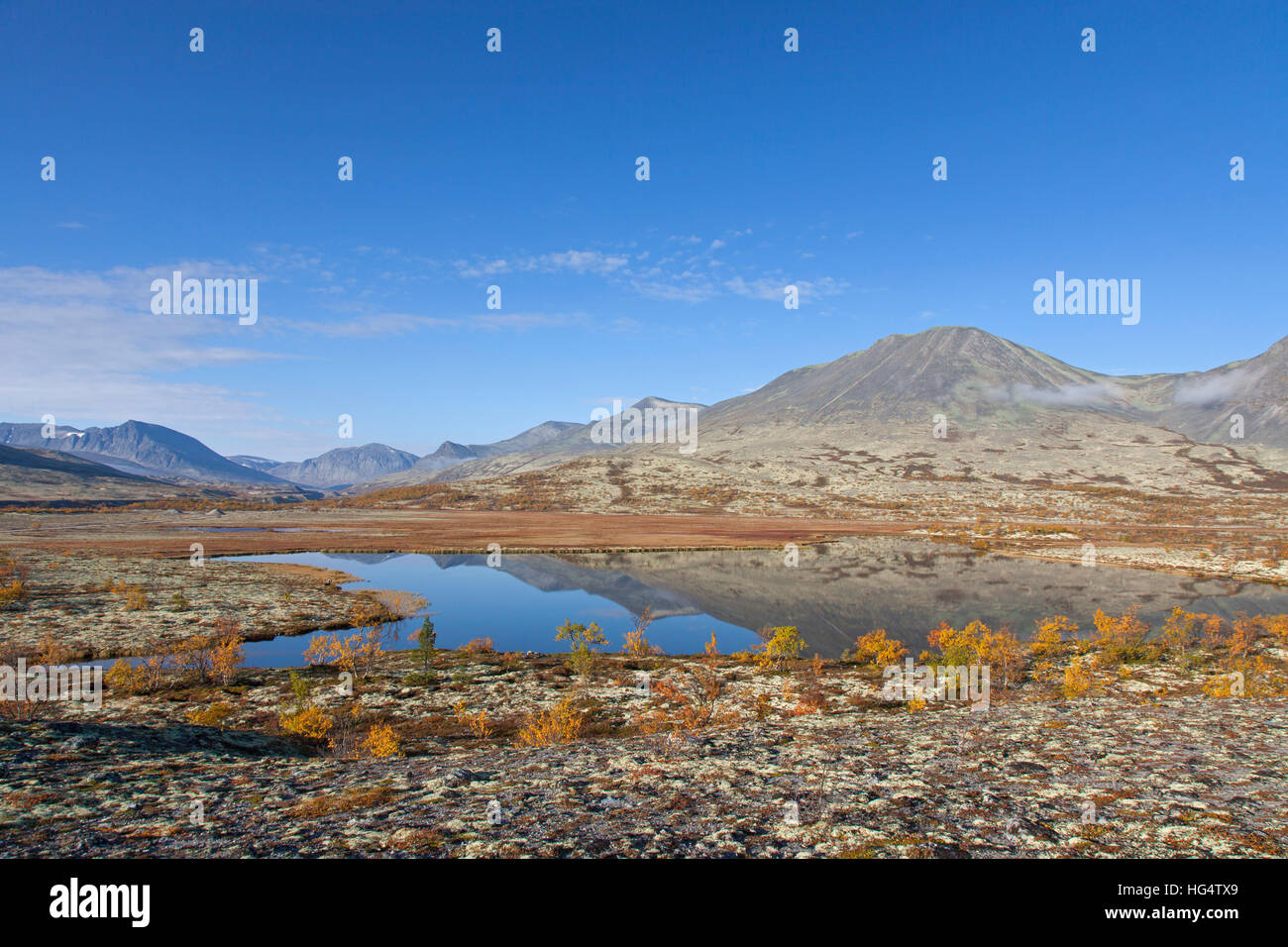 Lake in front of the mountain Stygghoin in autumn, Døråldalen in Rondane National Park, Oppland, Norway Stock Photo