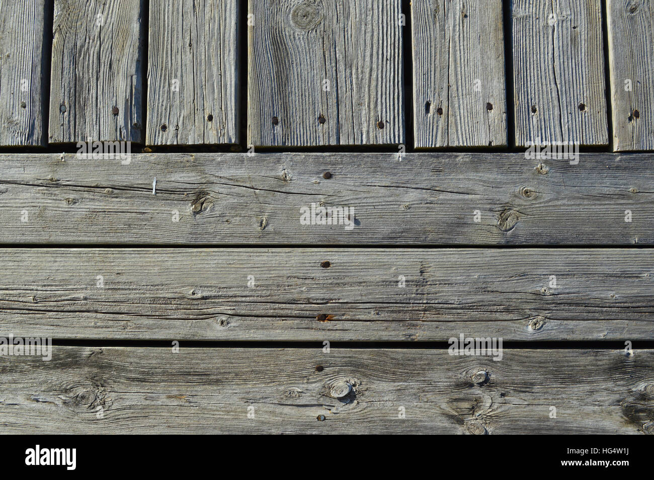 Silvery worn wood planks run both horizontally and vertically as a background with character Stock Photo