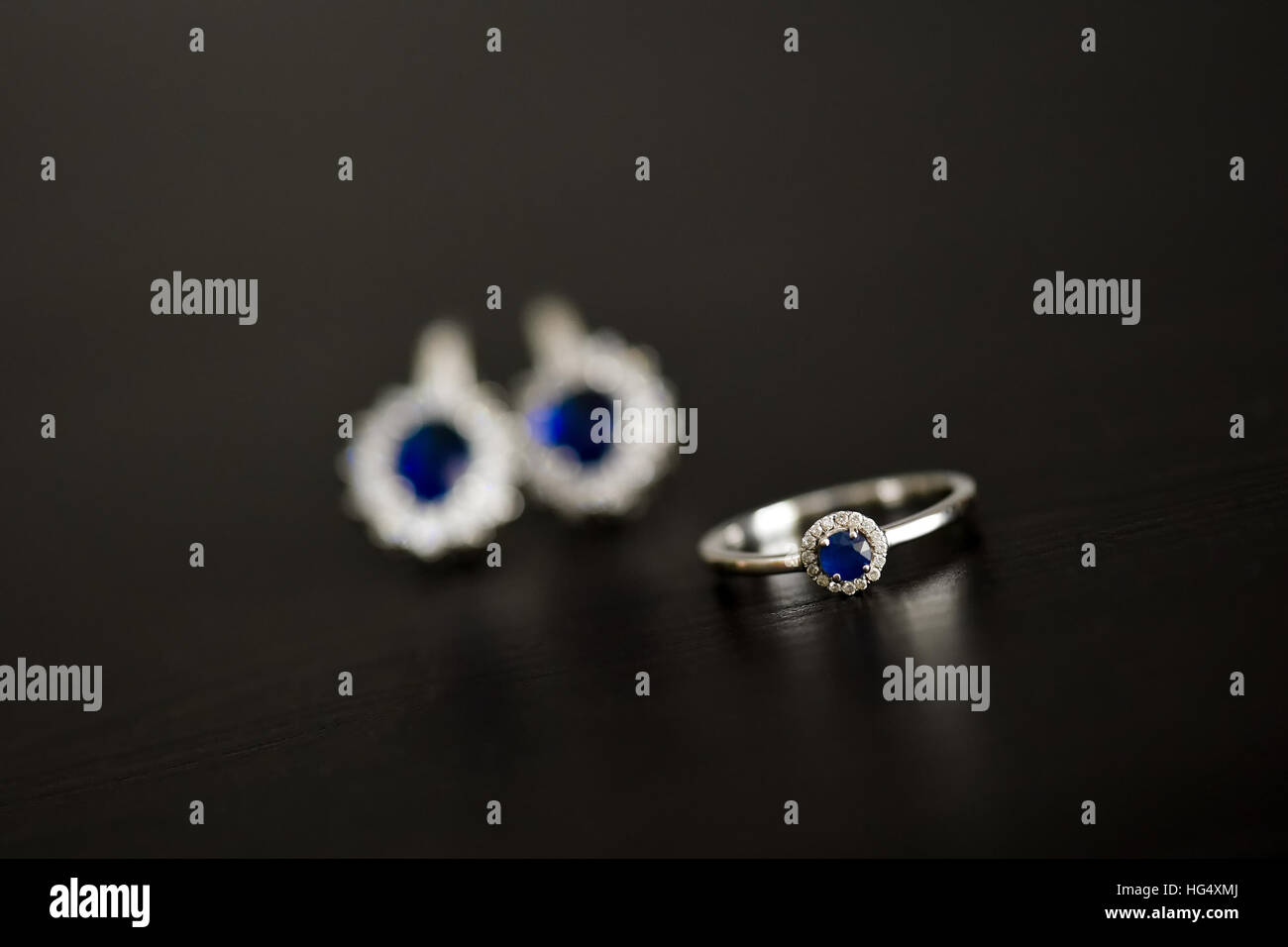 Ring and earrings with blue gemstone on the table in natural light Stock Photo