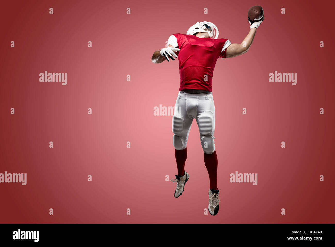 Football Player with a red uniform making a catch on a red background