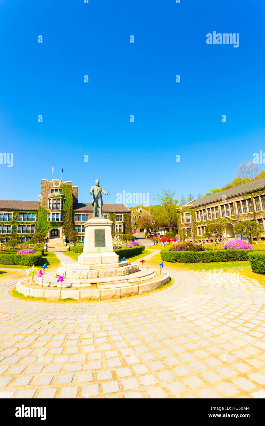 Ivy covered brick buildings surround the quad with Horace Grant Underwood statue at venerable Yonsei University in Seoul, Korea Stock Photo