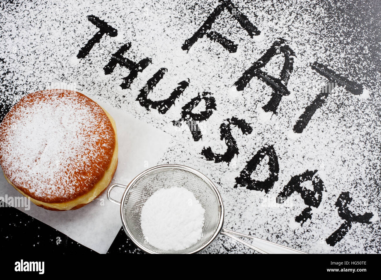 Fat Thursday. Donut and powdered sugar on dark background Stock Photo